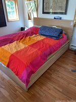 Three-quarter front view of queen bed frame with headboard and bedding removed.