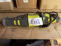 Side view of Ryobi corded reciprocating saw showing handle, power cord wrapped around, and label.