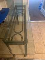 Top-down view of rectangular glass sofa table showing glass top and metal frame base with X crossbars