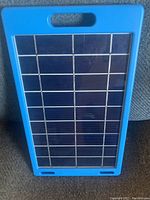 Front view of the rectangular blue solar charger showing the solar panel cell layout