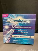 Front view of the iWant White Teeth Power Whitening System box in English, showing product name, features including 10+ whitening treatments, whitening gel, retainer case, 3-in-1 activation light, and perfect fit tray.