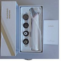 AEVO blackhead remover system in original packaging showing four suction heads and the main handheld device wrapped in protective plastic, with user manual alongside.