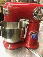 Front angled view of red stand mixer with stainless steel bowl attached