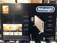Box showing DeLonghi brand, model HSX3315FtSCA, 1500 watt power, description of product features such as slim design, carry handle, timer, power settings, safety features.