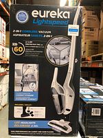 Box front showing product image, features, and specifications of Eureka Lightspeed 2-in-1 cordless vacuum cleaner with up to 60 minutes run time and LED headlights.