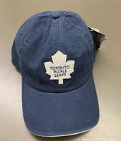 Front view showing navy blue color and embroidered white Toronto Maple Leafs maple leaf logo with text.