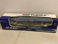 Boxed HT-3827 battleship model visible through the display window, showing detailed ship model inside.