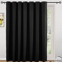 Full view of black curtain panel hanging on a curtain rod installed in front of a door with window panes.