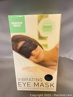 Front of retail packaging showing the black vibrating eye mask branding and product image.