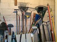 Multiple upright shovels, rakes, brooms, pruners