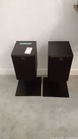 Front view of both speakers with grilles attached on stands