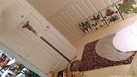 Overall view showing floor lamp standing beside a door with throw rugs on the floor including a multicolored one.