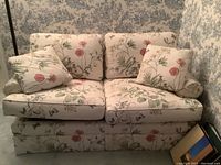 Full view of the Barrymore sofa bed showing floral cushions and two floral throw pillows.