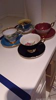 All four teacup and saucer sets displayed on countertop