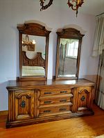 Front view of the wood dresser with two mirrors, showing detail of drawers, cabinet doors, and mirror frames.