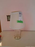 Front view of glass base table lamp with fabric shade, showing size label 9x14 inches