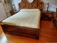 Full bedroom view showing the pair of wooden side tables flanking the bed, lamps on top not included.