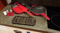 Set of cookware on kitchen countertop including pans and salt and pepper shakers