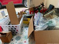 Wide view showing various tool boxes, containers of screws/bolts, and hand tools including a Hitachi drill on a table.