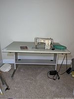 Full view of the Singer Fashion Mate Model 237 sewing machine installed in the white sewing table with metal legs and accessories on top.