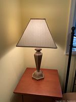 Tall table lamp with beige fabric shade on wooden base