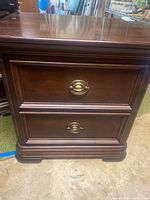 Front view of the end table showing two drawers and metal pulls.