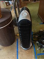 Full view of Honeywell black and silver tower floor fan showing front grille and base.