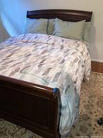 Front angled view of sleigh bed with linens and pillows