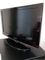 Front and side angle view of the Samsung 26 inch LCD TV showing the screen, bezel, and stand.
