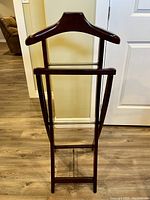 Front view of the wooden clothes valet with hanger and pant bar