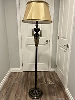 Full view of the floor lamp showing its height, metal base, marble column, and fabric shade.