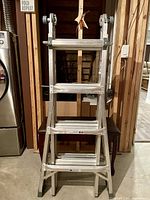 Full view of ladder set up in A-frame position in basement