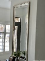 Full view of mirror hung on wall showing frame detail and relative size