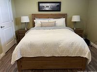 Full view of queen platform bed with headboard, footboard and two matching bedside tables