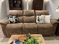 Front view of three-seat faux suede sofa with two reclining ends, decorative pillows placed on seating.