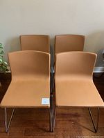 Front view of four brown leather chairs arranged in two rows.