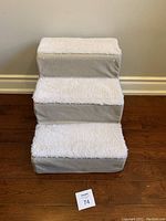 Front view of 3-step pet stairs with white fleece removable cover.