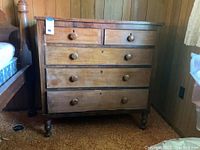 Full front view of distressed wood dresser with 5 drawers showing the overall condition, wood grain, and drawer knobs.