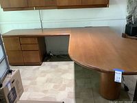 Full view of L-shaped executive desk showing main surface and return section with filing drawers underneath.