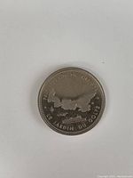 Reverse side of the coin showing map outline and French text