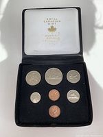 Full view of the 7 Canadian coins set in black velvet display case with white lid showing 'Royal Canadian Mint' branding.