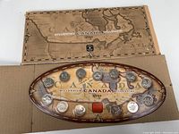 Full set of 1999 Canadian Millennium coins displayed in oval holder with accompanying outer box featuring Canada map design