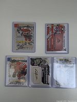 Front view of all 5 autographed hockey cards in protective sleeves showing player images and autograph placements