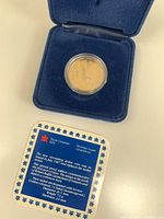 Photo of the 1987 Canadian Looney proof coin in a blue velvet case with certificate card