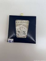 Photo of a Canadian 20 dollar silver coin in original navy packaging with visible maple leaf design and denomination 20.