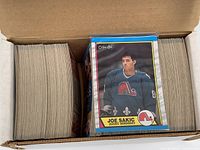 Opened box showing two stacks of 1989 O-Pee-Chee hockey cards, with Joe Sakic rookie card front and center in protective sleeve.