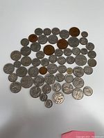 Photo showing a large group of 49 Australian coins of various types, sizes, and conditions spread on a white surface.