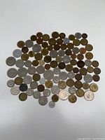 Photo showing a large group of German coins with various denominations and metals spread out on a white surface.