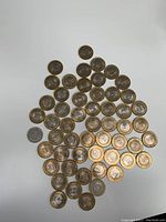 Photo shows approximately 58 Indian coins arranged on a white background including many 10 Rupee bimetallic coins and various smaller coins.