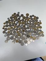 Image showing a scattered layout of over 100 Israeli coins of various sizes and colors, including silver and brass toned coins.